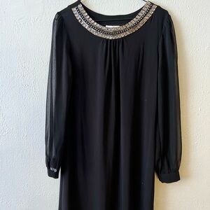 It’s a joy black dress with long transparent sleeves. She’s elegant